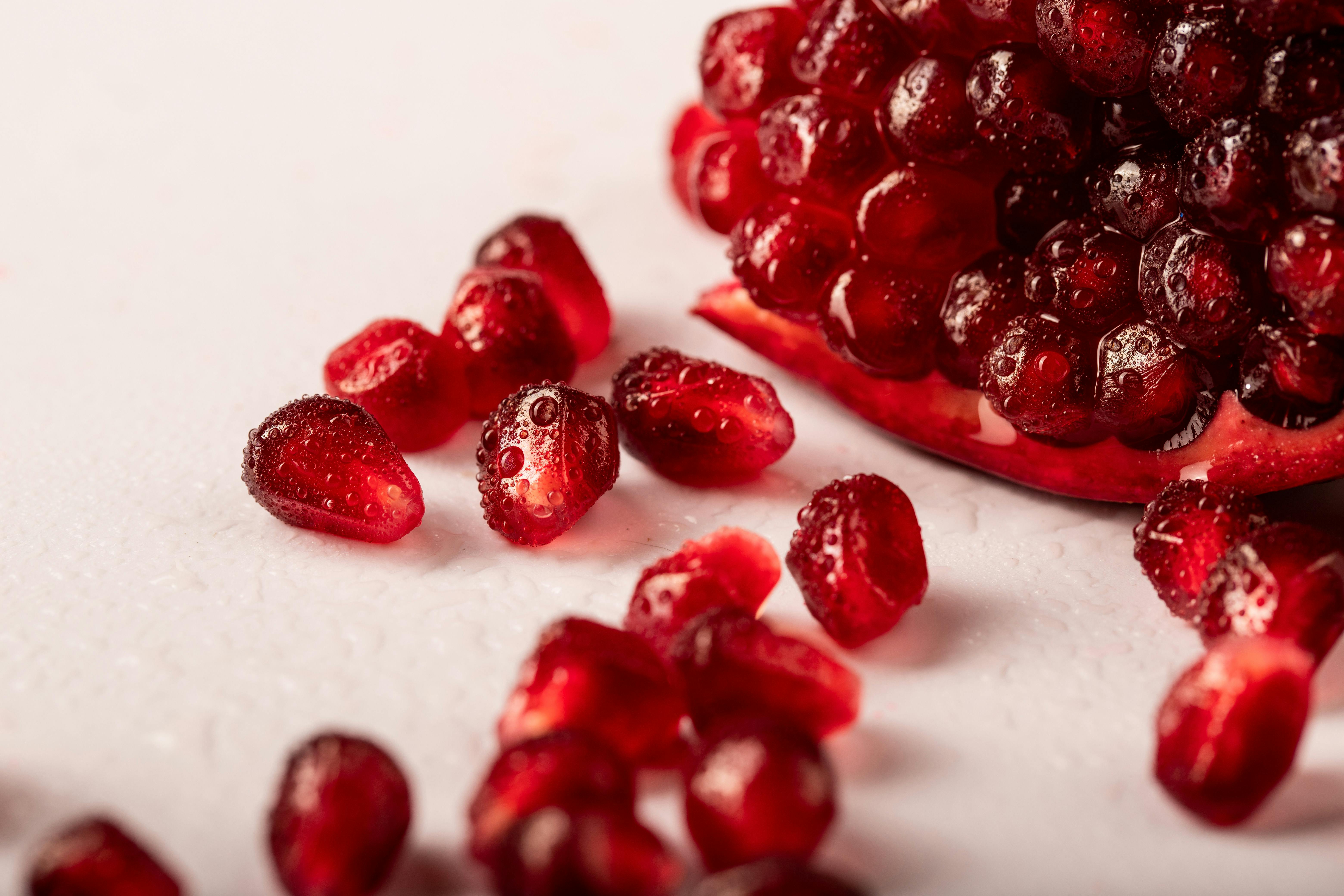 Vibrant close-up of juicy pomegranate seeds with droplets, ideal for healthy food concepts.