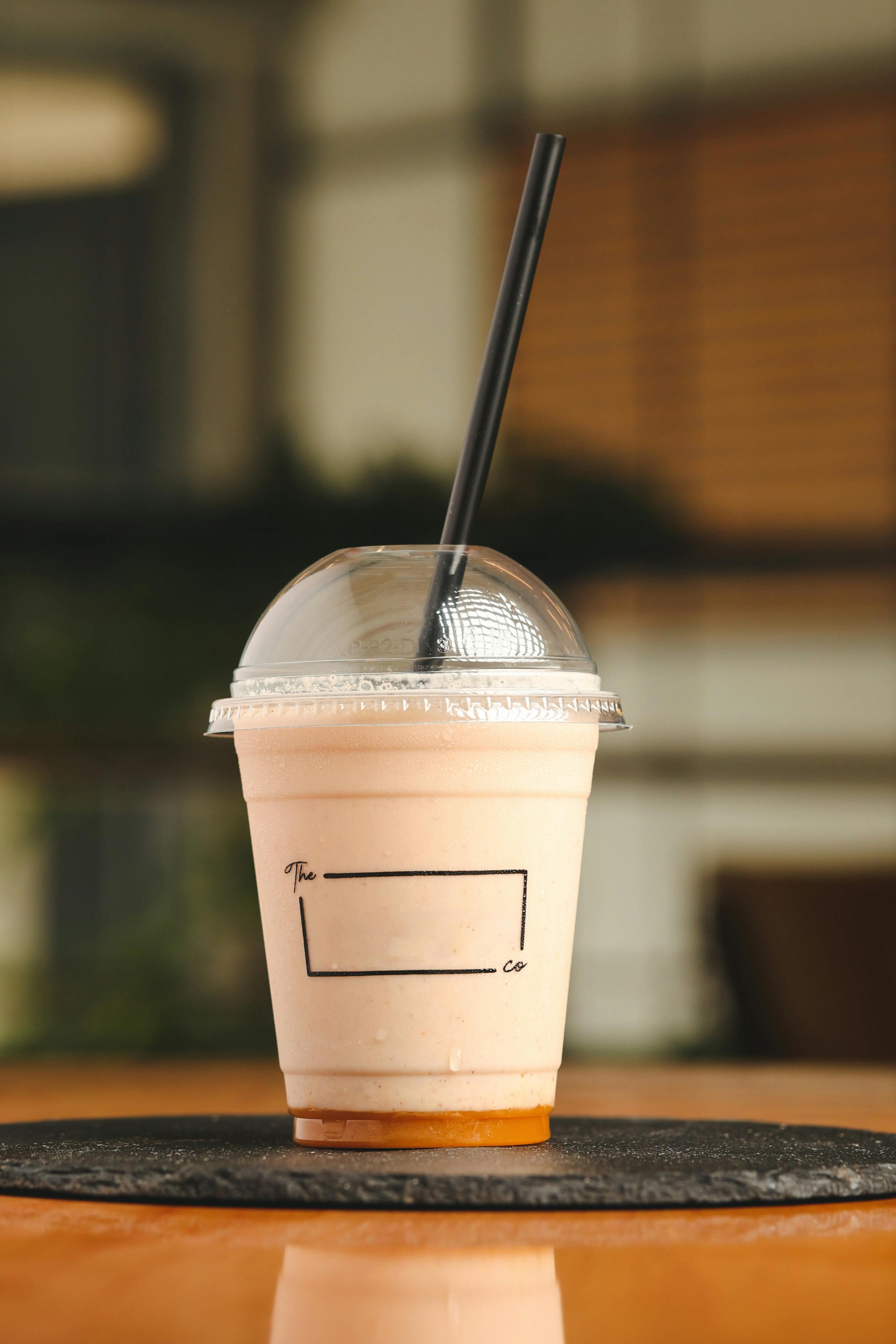 A delicious, creamy shake in a clear plastic cup with a black straw, perfect for a healthy lifestyle.